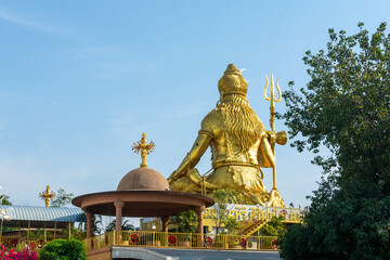Obraz premium Golden Shiva statue against blue sky, Big statue hindu god and spiritual landmark in Thailand