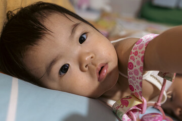 A curious toddler, gazing directly at the camera with a thoughtful expression.