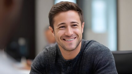 Obraz premium A man with a warm confident smile in a bright modern office setting exuding positivity and engagement