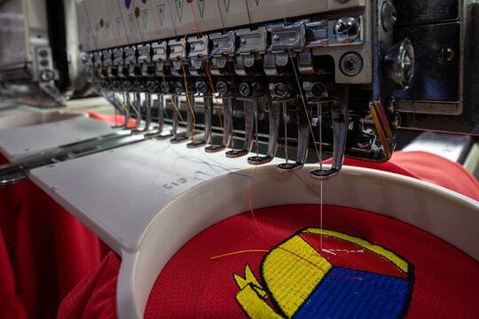 Close-up of Worker hand putting embroidery thread into embroidery needle at textile Industry at Garment Manufacture