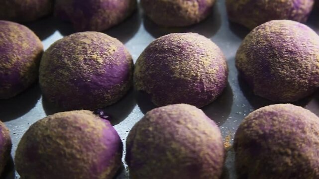 Freshly baked Filipino food called Ube Cheese Pandesal or Bread with yam jam and cheese filling.