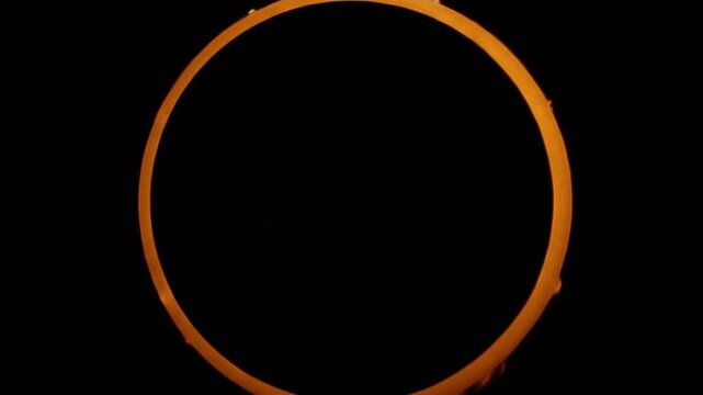 Annular solar eclipse isolated on black background rotating.
