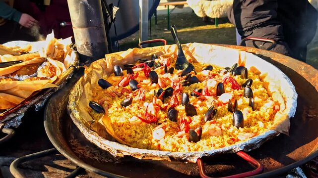 Street food market with a big pan of colorful seafood paella in Latvia