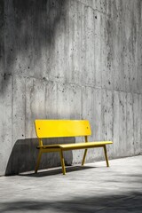 Bright yellow bench on a stark gray concrete backdrop with minimalist composition