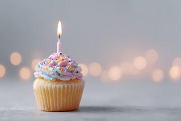 Celebration cupcake on a pale gray tabletop, dreamy background lights and room for headline