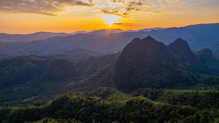 Breathtaking sunset view amidst a backdrop of rolling mountains and lush forests in Thailand