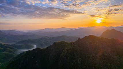 Breathtaking sunset view amidst a backdrop of rolling mountains and lush forests in Thailand