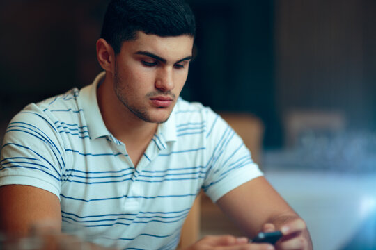 Sad Man Holding His Phone Reading a Text Message. Stressed guy staring at his smartphone screen after a notification 
