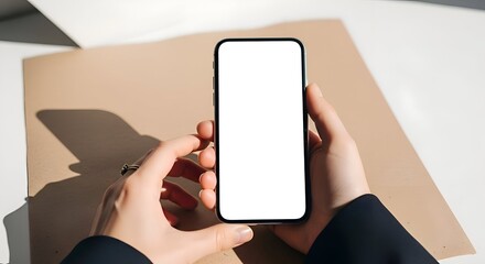 Close Up Female Hands Holding Modern Black Smartphone Blank White Screen Over Brown Paper On White Table Surface With Bright Sunlight