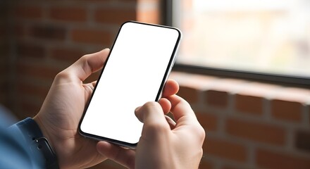 Close Up of Hands Holding Smartphone with Blank Screen against Brick Wall Background Near Window