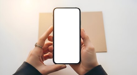 Woman Holding Smartphone with Blank Screen Above Brown Paper on White Surface