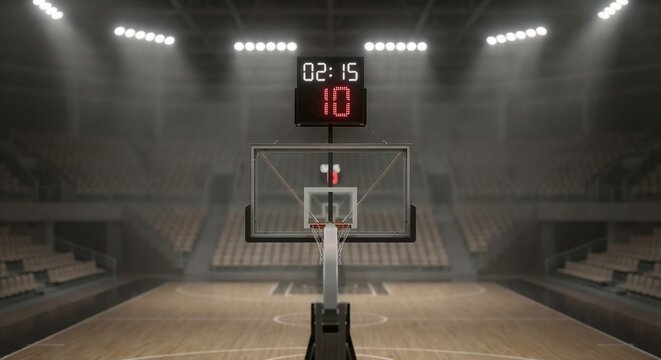 Empty basketball court with scoreboard and backboard at night