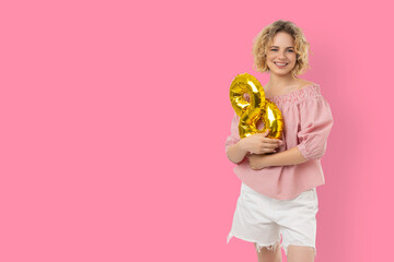Fototapeta premium Woman holds gold balloons shaped like the number 8