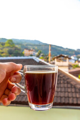 Fototapeta premium Black coffee with tropical landscape terrace balcony panorama view Thailand.
