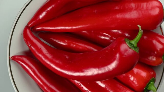 Premium close-up of a vibrant red Capia sweet pepper rotating smoothly on a clean white background. The surface is covered with delicate water droplets, emphasizing freshness and crispness. Perfectly 