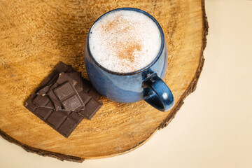 A cup of delicious, aromatic coffee with chocolate pieces on a dark background