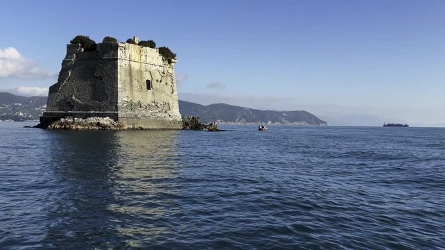 Stone sea fort of Scola Tower (Torre Scola) off Palmaria Island in Porto Venere, Gulf of Poets (La Spezia), Liguria, Italy, surrounded by calm blue water on a clear day