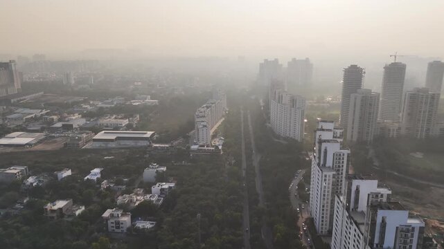 Top-down aerial perspective of Swarn Nagri Road featuring parallel apartment blocks and lush green corridors, partially obscured by smog, capturing modern urban expansion amid rising air pollution