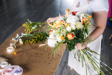 Florist demonstrates bouquet assembly during botanical art education session. Community workshop, florist teaching, experiential marketing.
