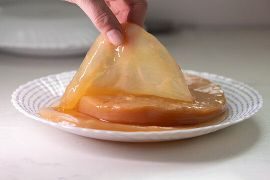 Glossy Kombucha Scoby On Plate Home Fermenter Gently Lifts Translucent Pellicle, Amber Liquid Pooling, Closeup Kitchen Countertop, Tactile Glossy Texture, Probiotic Culture Ready