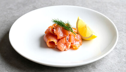 Smoked salmon appetizer with fresh dill and lemon wedge in a white plate.