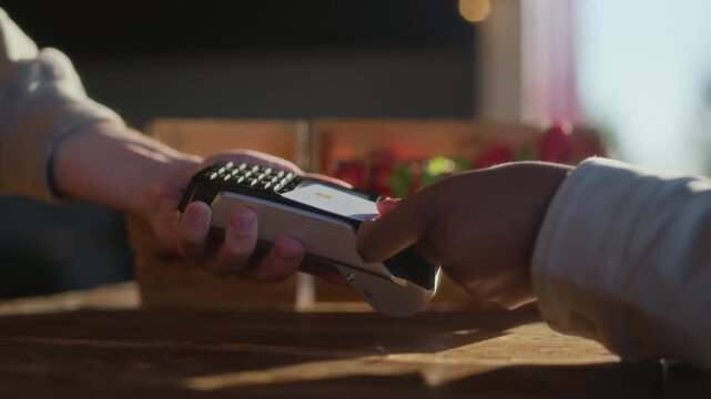 Closeup of customer paying with credit card at farm strawberry market counter with fresh produce and rustic outdoor setting