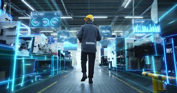 Black Male Technician Walks Down a High-tech Factory Aisle as Holographic AR Panels and Digital Twin Grids Scan Equipment, Display Kpi Charts, Stream Iot for Smart Manufacturing, Automation