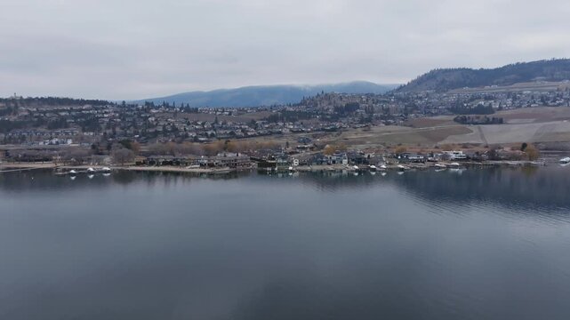 Winter flight towards houses by a mountain lake