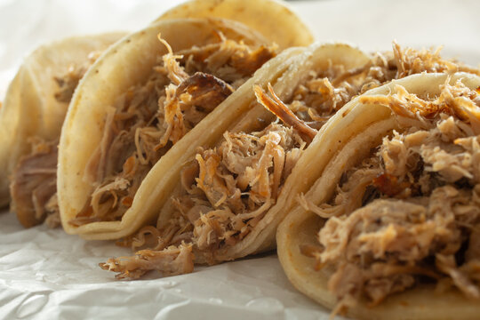 A closeup view of several carnitas tacos.