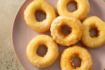 Naklejka premium A top down view of a plate of dairy-free, gluten-free glazed donuts.