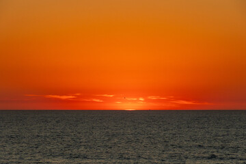 Obraz premium Deep orange afterglow illuminating the sky above the calm Atlantic, Portugal, Ovar – Furadouro, 10.10.2025