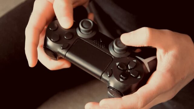 Close up of male hands playing with black gaming controller