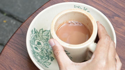 Traditional coffee cup on a saucer, placed on a wooden table