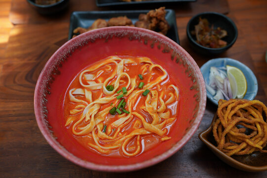 Thai Food, Northern Style Curried Noodle Soup or what we call in thai Khao Soi on wooden table.