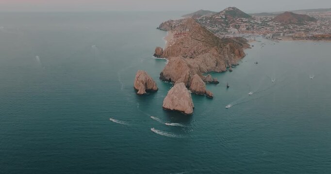 Aerial view of boats sailing past the rugged El Arco rock formation at Land's End, where the Pacific meets the Gulf of California, Cabo San Lucas, Baja California Sur, Mexico.