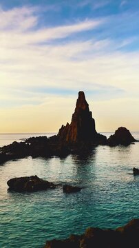 seascape with rock basaltic formation, vertical video