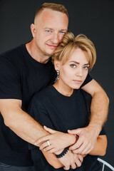 Fototapeta premium Couple embraces in a studio setting during a casual moment together