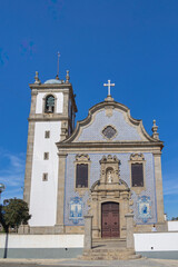 Fototapeta premium Historic catholic church with bell tower and azulejo facade under blue sky, Portugal, Ovar – Furadouro, 14 October 2025