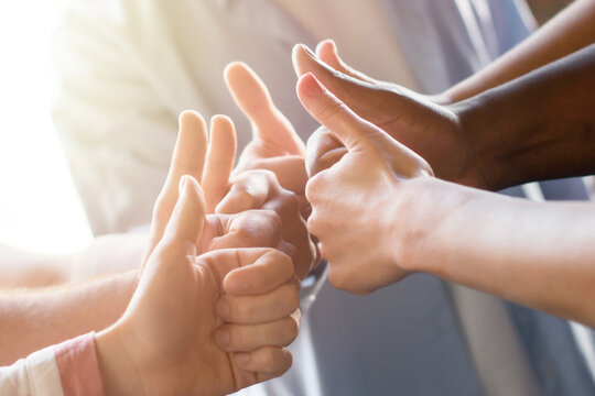 Diverse team giving thumbs up together