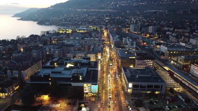 Evening aerial over Vevey main avenue with Lake Geneva and Lavaux vineyards