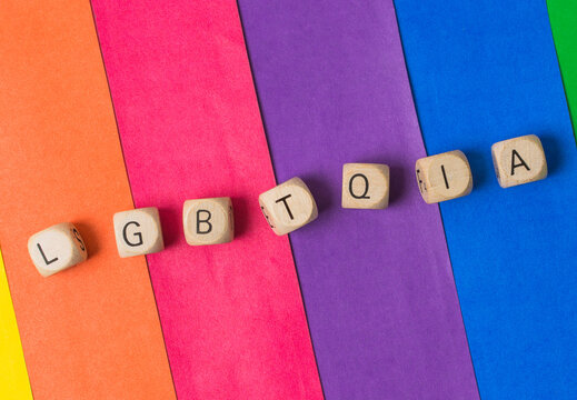 Lgbtqia wooden cubes arranged on a colorful rainbow background
