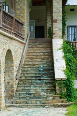 Naklejka premium view of the facade of an old house with a stone steps and porch and arches