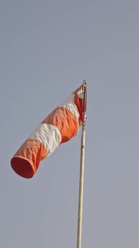 Striped windsock at the background of overcast sky