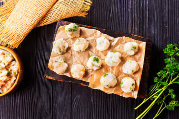 Homemade beef and pork meatballs on baking paper.