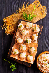 Homemade beef and pork meatballs on baking paper.