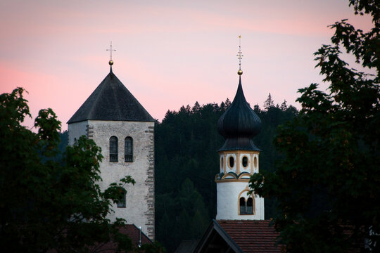 Blick auf die Kircht&uuml;rme zweier Kirchen in San Candido im s&uuml;dtiroler Pustertal in der Abendd&auml;mmerung