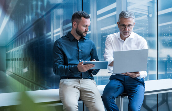 Business team collaborating on digital data analysis in modern office