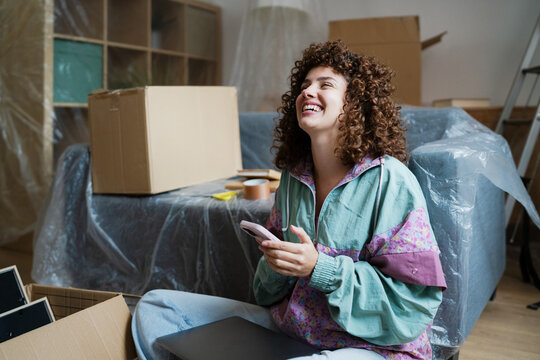 Happy woman relaxing while moving into a new home