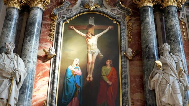 Footage of a large religious oil painting depicting Jesus on the cross surrounded by baroque architecture.