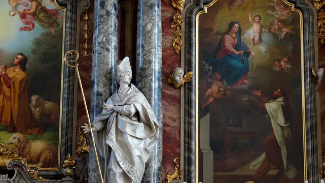 Panning view of the framed religious paintings and artwork inside Einsiedeln Abbey.
